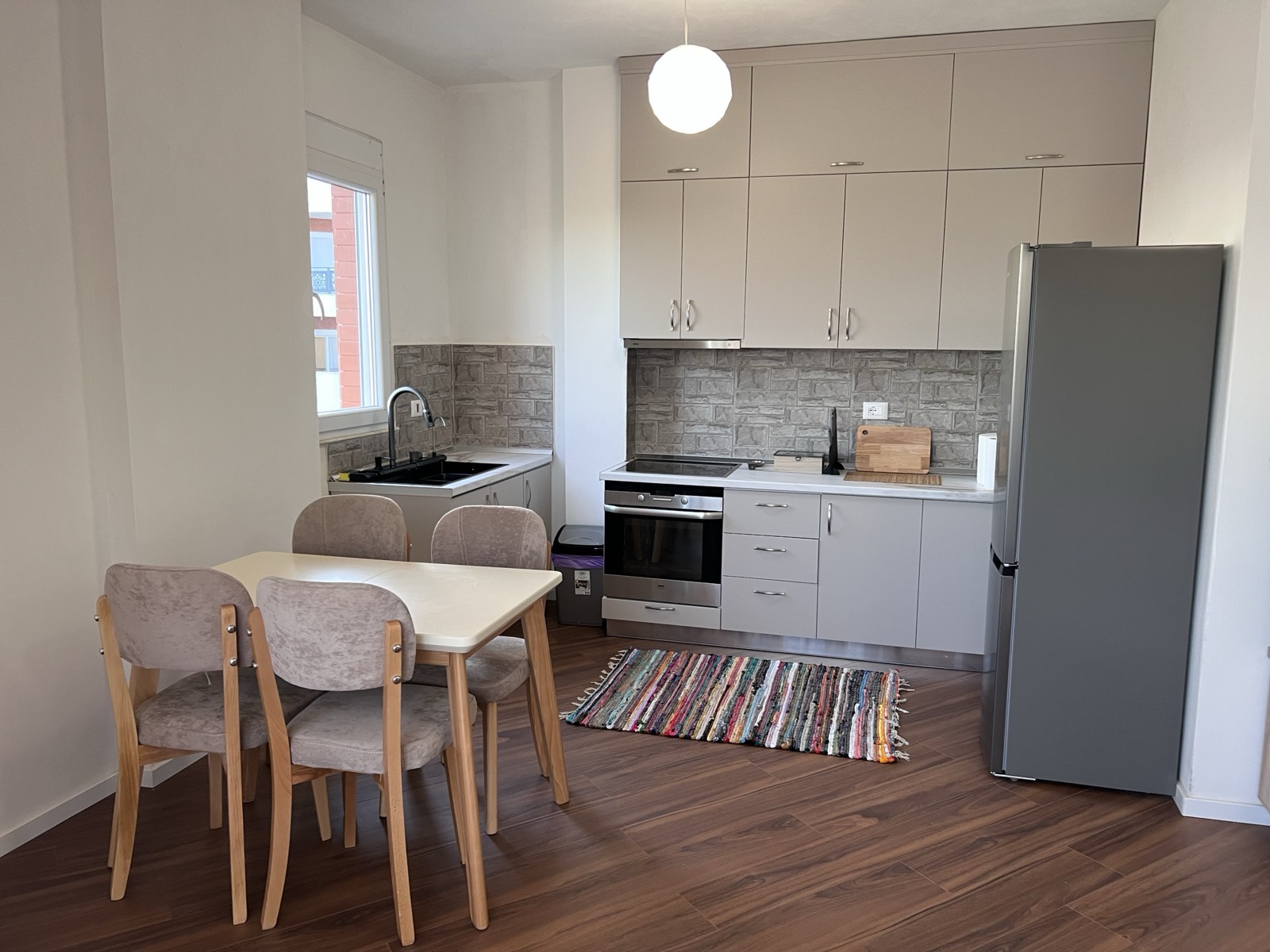 Kitchen and dining area with oven, induction hob, full-size fridge and seating for four